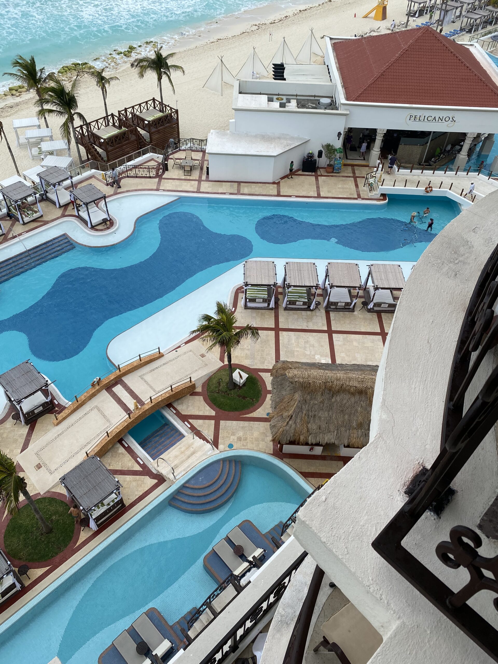 "Aerial view of a white-sand beach with turquoise water, symbolizing personalized travel planning by The Destination Specialists."